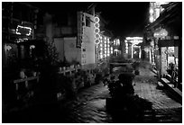 Red lanterns reflected in a canal at night. Lijiang, Yunnan, China (black and white)