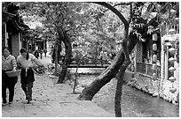 Naxi women walk along a canal. Lijiang, Yunnan, China ( black and white)