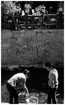 Women washing clothes in a canal. Lijiang, Yunnan, China ( black and white)