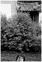 Naxi woman sitting next to a canal. Lijiang, Yunnan, China ( black and white)