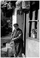 Naxi woman at the door of her wooden house. Lijiang, Yunnan, China ( black and white)