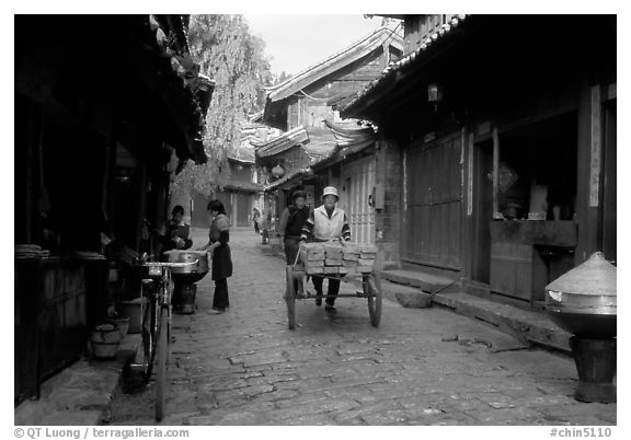 Early morning activity in a cobblestone street. Lijiang, Yunnan, China (black and white)