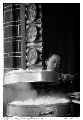 Woman baking dumplings. Lijiang, Yunnan, China (black and white)