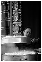 Woman baking dumplings. Lijiang, Yunnan, China (black and white)