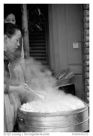 Naxi Women baking dumplings. Lijiang, Yunnan, China (black and white)