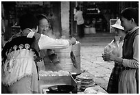 Naxi Women preparing the baba flatbreat. Lijiang, Yunnan, China (black and white)