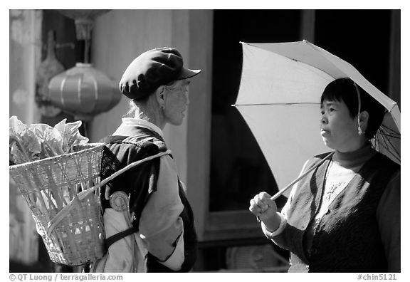 Two women conversing in the street. Lijiang, Yunnan, China (black and white)