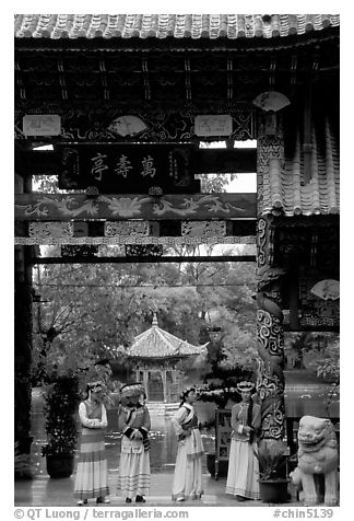 Women in Naxi dress standing in an archway. Lijiang, Yunnan, China (black and white)