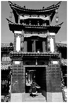 Woman under the Kegong tower archway. Lijiang, Yunnan, China (black and white)