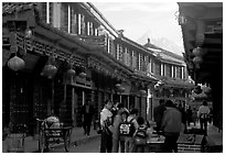 Schoolchildren get Naxi flatbread for breakfast, Jade Dragon Snow Mountain in the background. Lijiang, Yunnan, China ( black and white)