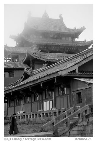 Monk beneath Jinding Si (Golden Summit) temple in the fog. Emei Shan, Sichuan, China