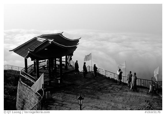 Monks and pilgrims admiring a sea of cloud from the summit. Emei Shan, Sichuan, China (black and white)