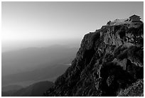 Jinding Si temple perched on a precipituous cliff at sunrise. Emei Shan, Sichuan, China (black and white)