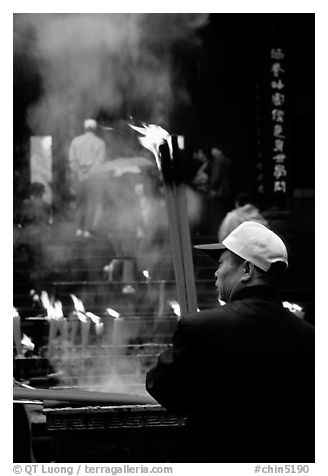 Pilgrim offering big incense stick. Emei Shan, Sichuan, China (black and white)