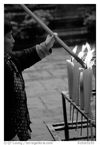 Woman Pilgrim lighting a large incense stick, Wannian Si. Emei Shan, Sichuan, China