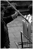 Woman Pilgrim lighting a large incense stick, Wannian Si. Emei Shan, Sichuan, China (black and white)