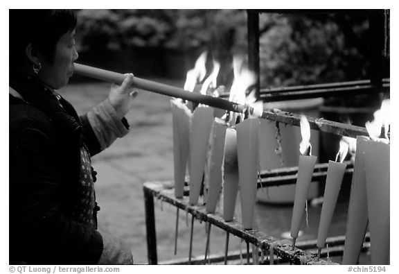 Woman Pilgrim lighting a large incense stick, Wannian Si. Emei Shan, Sichuan, China