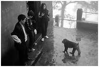 Pilgrims show the palm of their hand to an aggressive monkey, meaning they have no food, Yuxian temple. Emei Shan, Sichuan, China ( black and white)