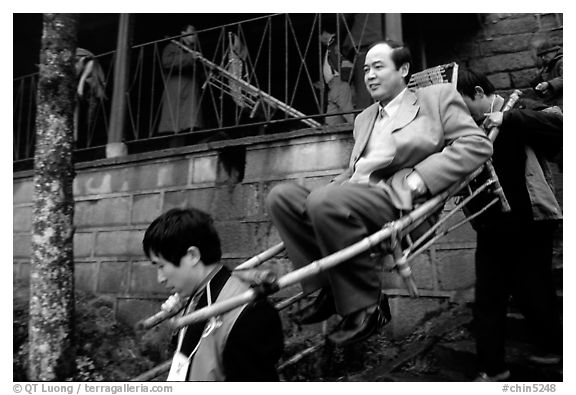 Wealthy pilgrim carried down Jieyin Palace on a chair. Emei Shan, Sichuan, China (black and white)