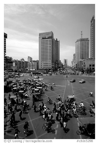 Pedestrians and bicyclists cross a major avenue. Chengdu, Sichuan, China (black and white)