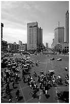 Pedestrians and bicyclists cross a major avenue. Chengdu, Sichuan, China ( black and white)