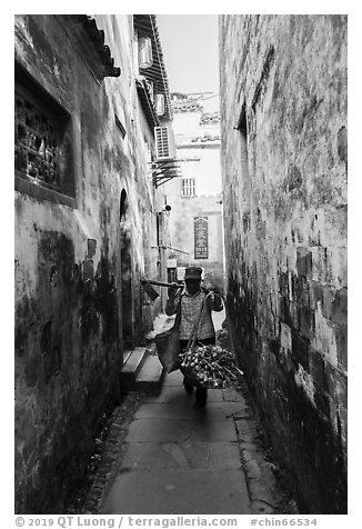 Woman returning from harvest. Xidi Village, Anhui, China (black and white)