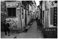 Woman standing next to main street. Xidi Village, Anhui, China ( black and white)