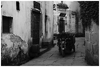 Man driving motobike carriage in narrow street. Xidi Village, Anhui, China ( black and white)
