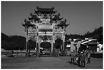 Villagers heading towrds fields, and Hu Wenguang Memorial Arch. Xidi Village, Anhui, China ( black and white)