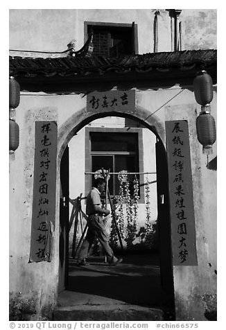 Man with garlic braids hung to dry. Xidi Village, Anhui, China (black and white)