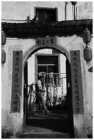 Man with garlic braids hung to dry. Xidi Village, Anhui, China ( black and white)