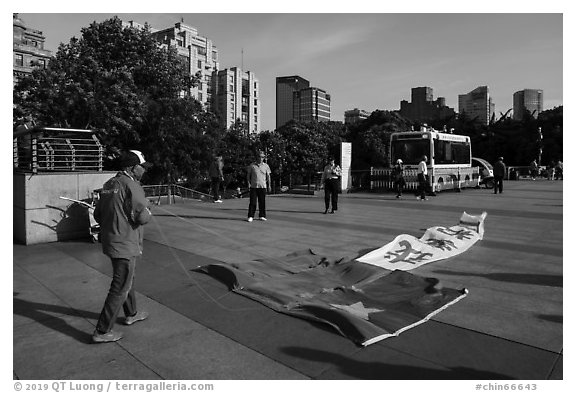 Man with kite on the ground, the Bund. Shanghai, China (black and white)