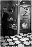 Man poking fighting crickets with stick. Shanghai, China ( black and white)