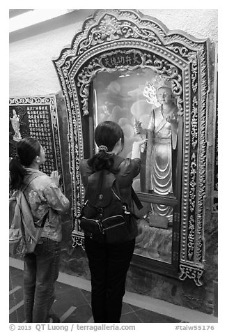 Women pray to deity, Guandu Temple. Taipei, Taiwan