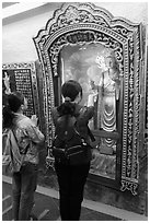 Women pray to deity, Guandu Temple. Taipei, Taiwan (black and white)