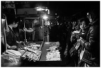 Sampling snacks at Shilin Night Market. Taipei, Taiwan (black and white)