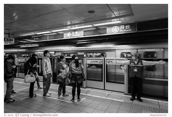 Subway with staff directing passengers. Taipei, Taiwan (black and white)