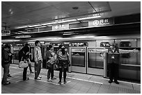 Subway with staff directing passengers. Taipei, Taiwan (black and white)