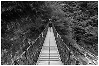 Hiker on suspension footbridge, Taroko Gorge. Taroko National Park, Taiwan (black and white)