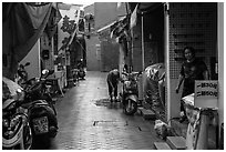 Woman cleaning in alley. Lukang, Taiwan (black and white)