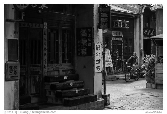 Man on bicycle amidst old houses in alley. Lukang, Taiwan