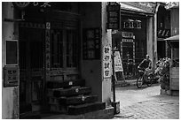 Man on bicycle amidst old houses in alley. Lukang, Taiwan (black and white)