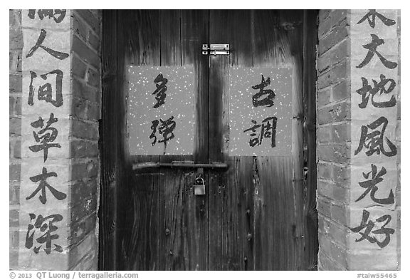 Wooden door and brick wall with Chinese writing. Lukang, Taiwan (black and white)