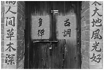 Wooden door and brick wall with Chinese writing. Lukang, Taiwan ( black and white)