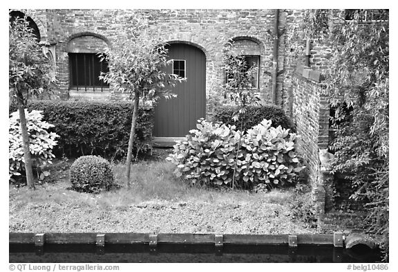 Small garden and brick house by the canal. Bruges, Belgium