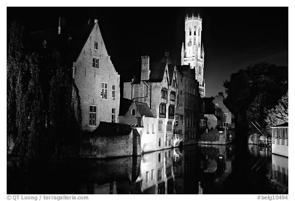 Old houses and beffroi reflected in canal at night. Bruges, Belgium