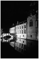 Houses and bridge reflected in canal at night. Bruges, Belgium (black and white)