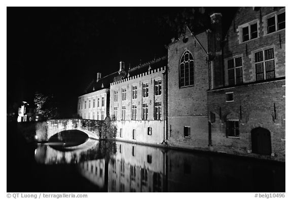 Bridge and houses reflected in canal at night. Bruges, Belgium