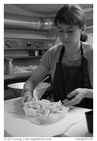 Woman serving fries in a booth. Bruges, Belgium