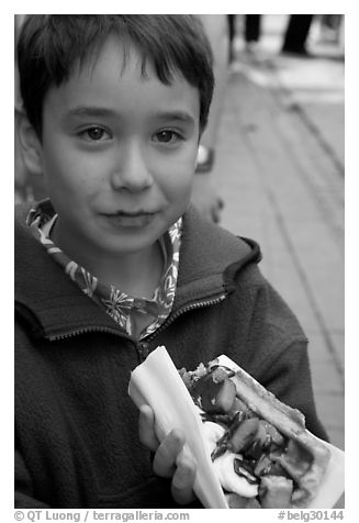 Boy eating a Belgian waffle. Brussels, Belgium